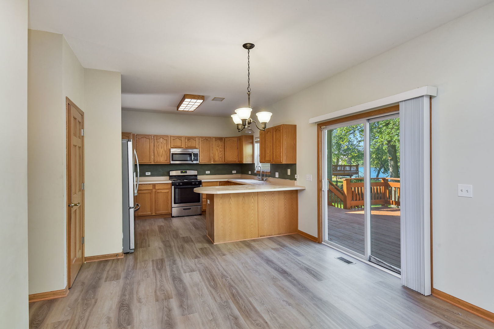 732 Robertson Road South Elgin, IL 60177 - Photo 6 of 37 a kitchen with stainless steel appliances granite countertop a refrigerator a sink dishwasher a stove and a dining table with wooden floor