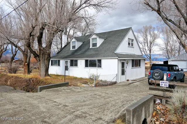 a white house that has a tree in front of it
