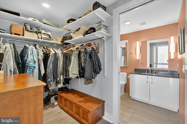 a view of walk in closet with clothes and shoes