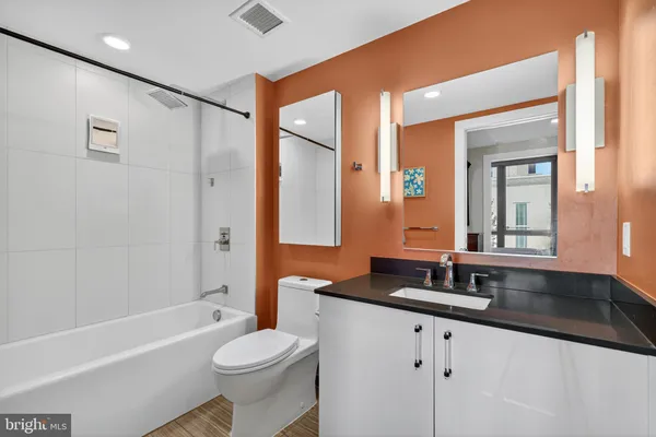 a bathroom with a granite countertop sink toilet and shower