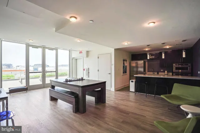 a living room with furniture a large window with kitchen view