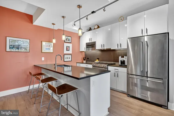 a kitchen with stainless steel appliances a refrigerator and a stove top oven