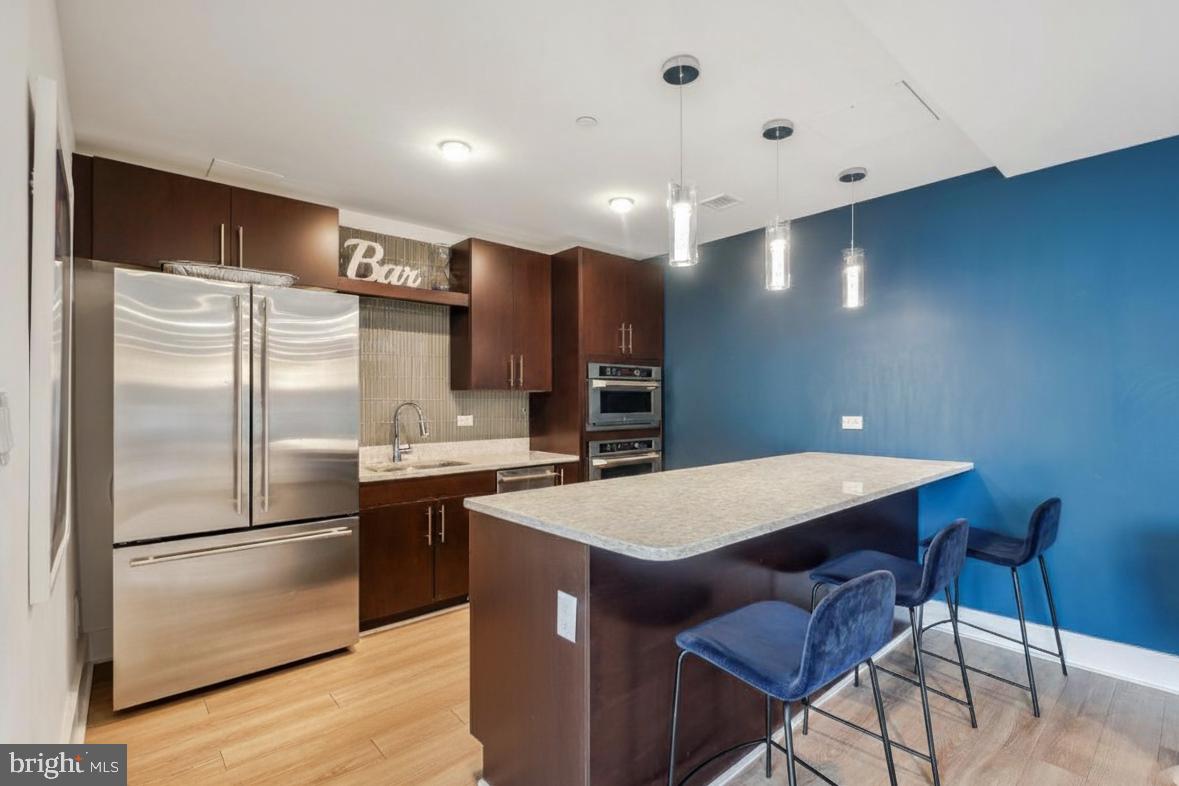 88 V Street Southwest, Unit 313 Washington, DC 20024 - Photo 31 of 38 a kitchen with stainless steel appliances granite countertop a refrigerator a sink dishwasher a stove with wooden floor