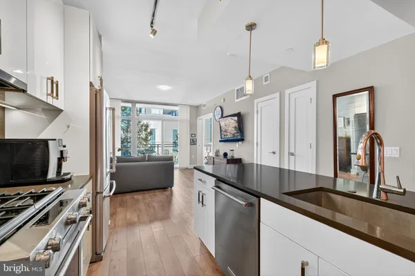 a kitchen with stainless steel appliances a sink stove and microwave