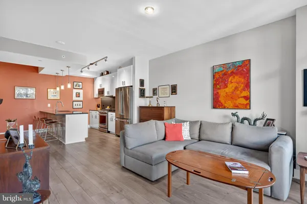 a living room with furniture and a dining table with kitchen view