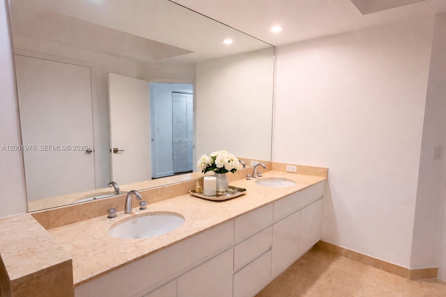 848 Brickell Key Drive, Unit 905 Miami, FL 33131 - Photo 12 of 28 a bathroom with a granite countertop sink a large mirror and shower
