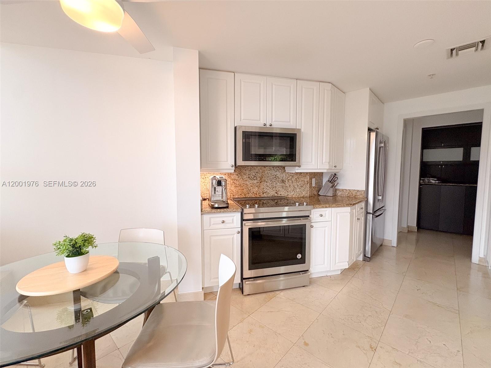 848 Brickell Key Drive, Unit 905 Miami, FL 33131 - Photo 16 of 28 a living room with furniture a fireplace and a flat screen tv