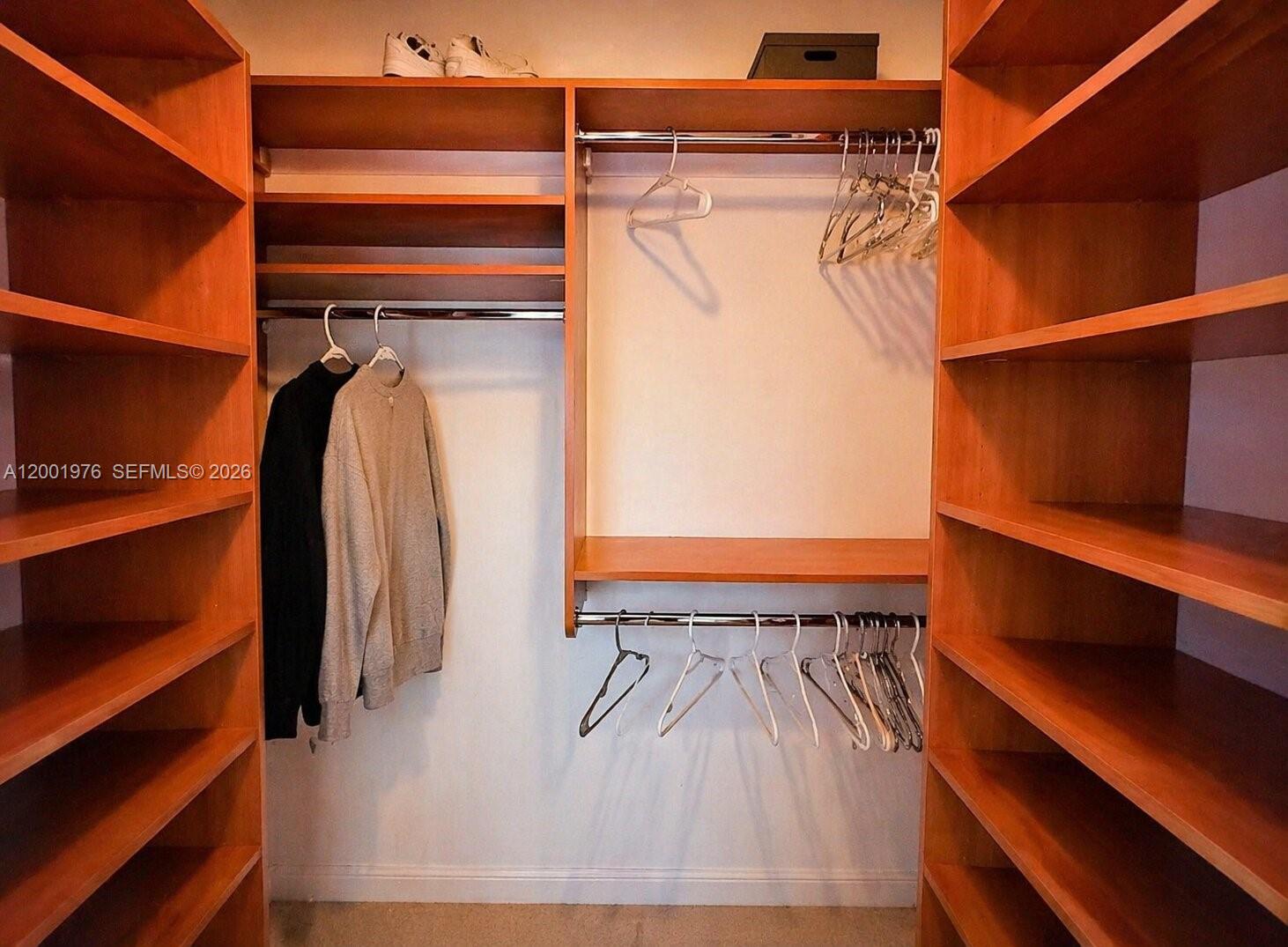 848 Brickell Key Drive, Unit 905 Miami, FL 33131 - Photo 20 of 28 a view of walk in closet with clothes and shoes