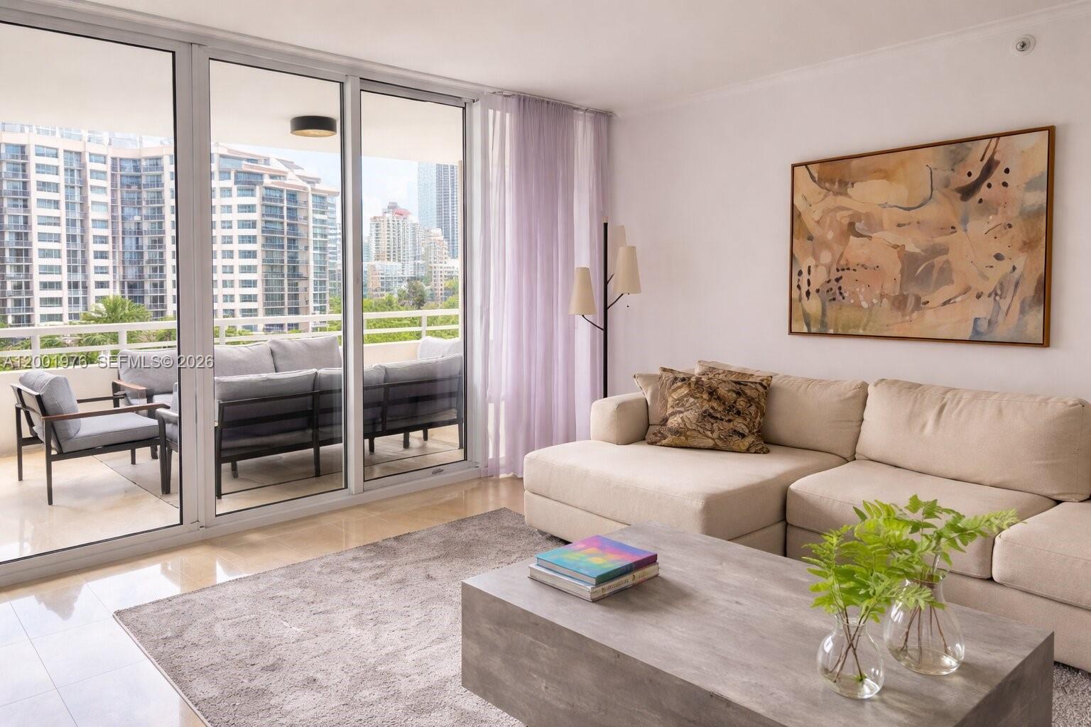 848 Brickell Key Drive, Unit 905 Miami, FL 33131 - Photo 2 of 28 a living room with furniture and a large window