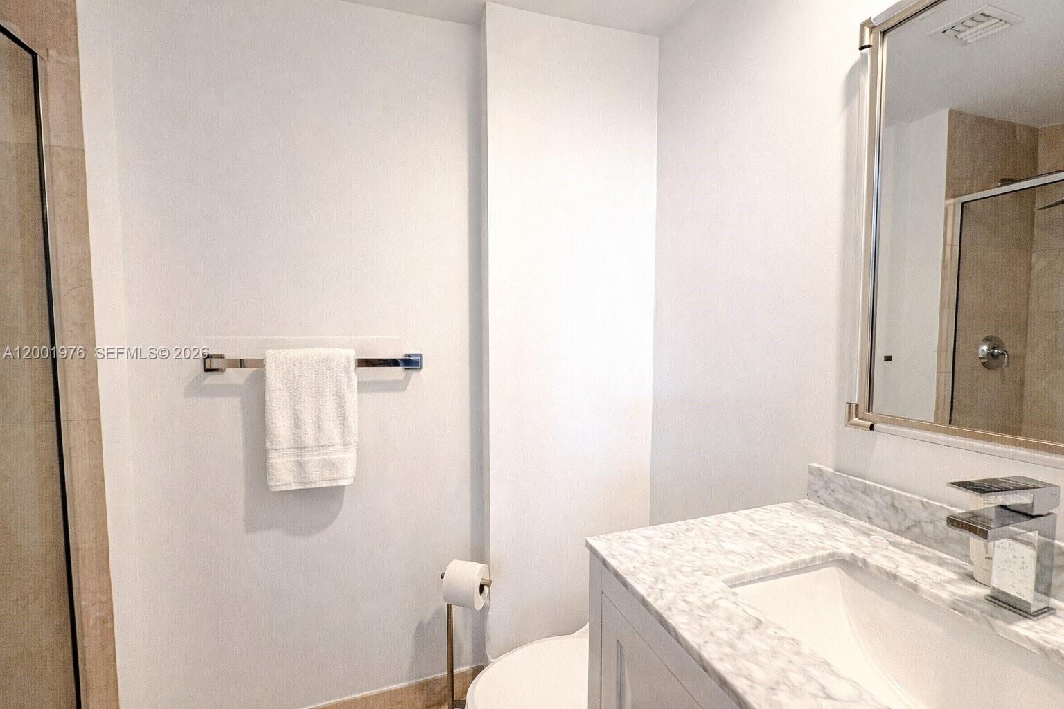 848 Brickell Key Drive, Unit 905 Miami, FL 33131 - Photo 21 of 28 a bathroom with a granite countertop sink and a mirror