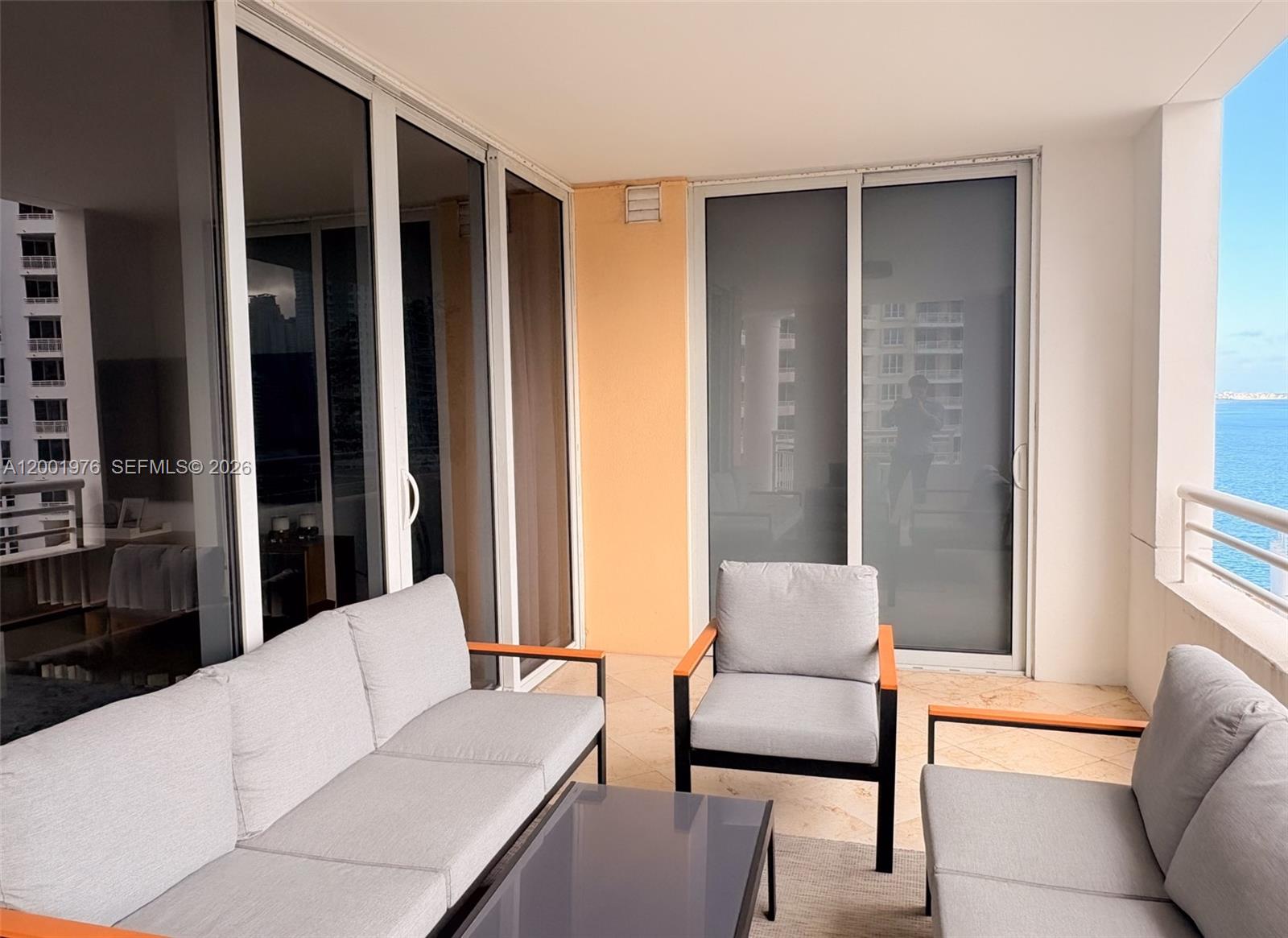 848 Brickell Key Drive, Unit 905 Miami, FL 33131 - Photo 24 of 28 a living room with furniture and a large window