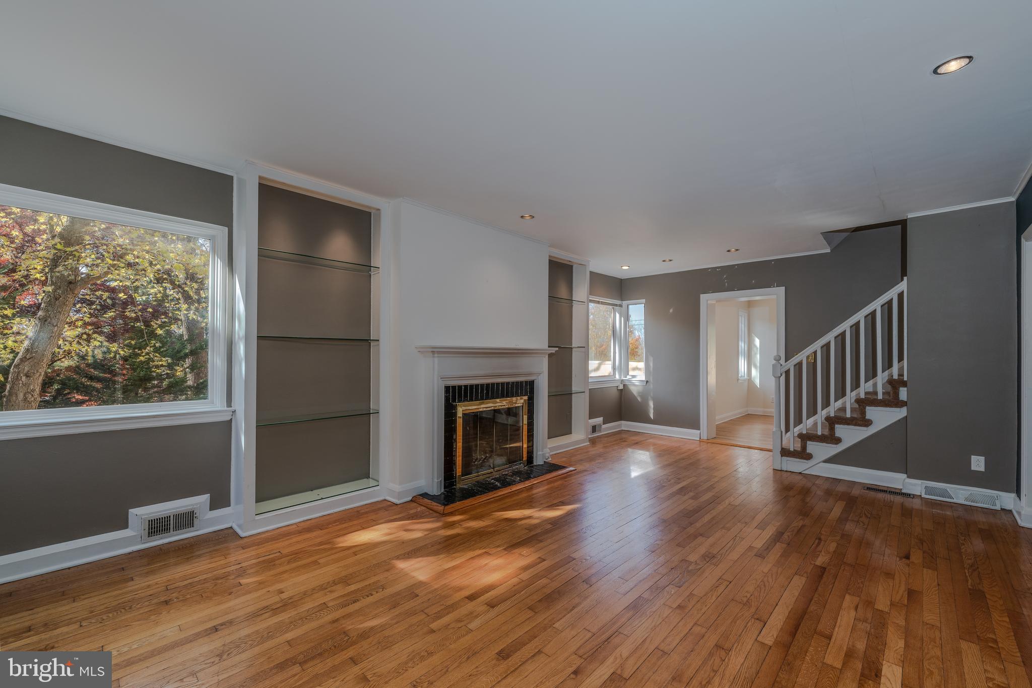 1012 Poplar Hill Road Baltimore, MD 21210 - Photo 5 of 42 a view of an empty room with wooden floor fireplace and a window