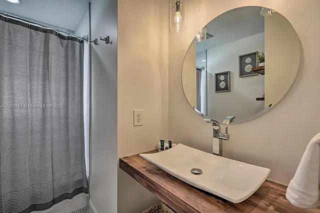 a bathroom with a tub sink and mirror