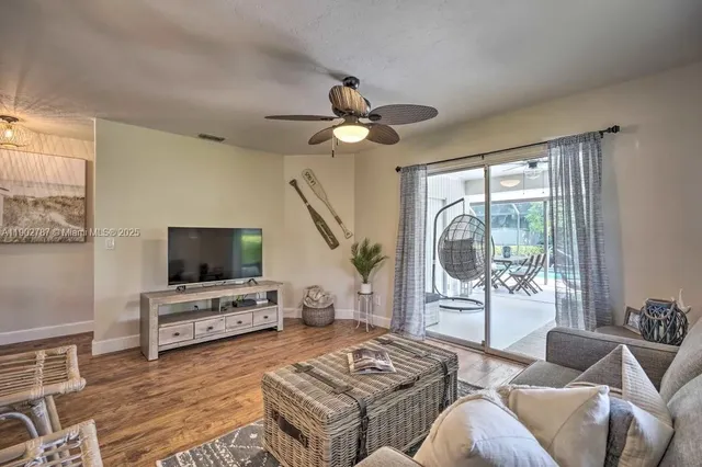 a living room with furniture a flat screen tv and a large window