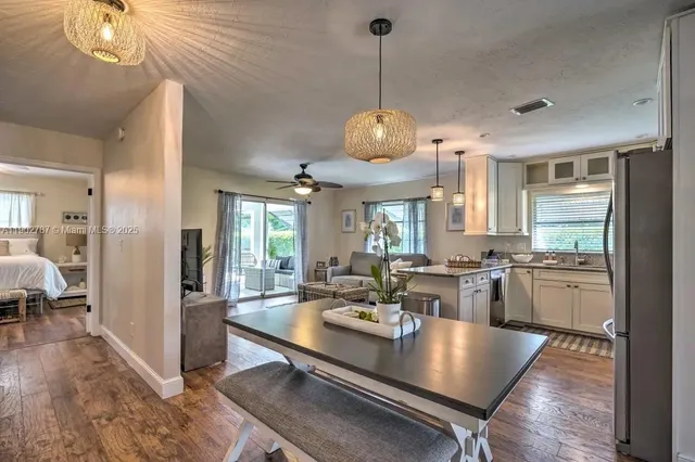 a view of a dining room and livingroom with furniture wooden floor a chandelier