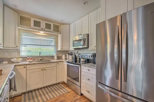 a kitchen with stainless steel appliances a refrigerator sink and cabinets