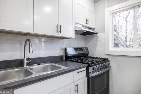 a kitchen with stainless steel appliances granite countertop a sink stove and cabinets