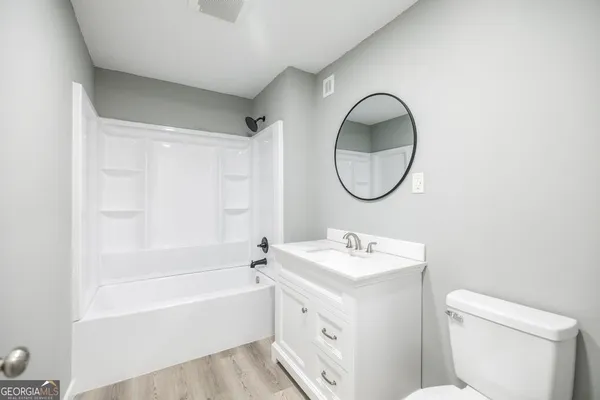 a bathroom with a sink a toilet and a mirror