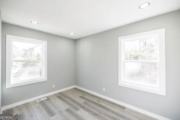 a view of empty room with wooden floor