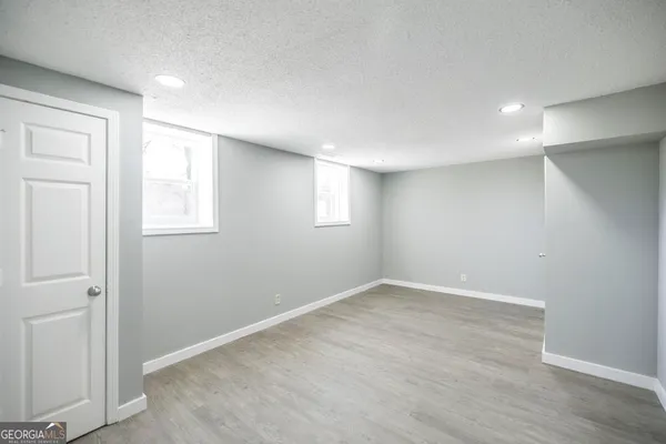 an empty room with wooden floor & closet area