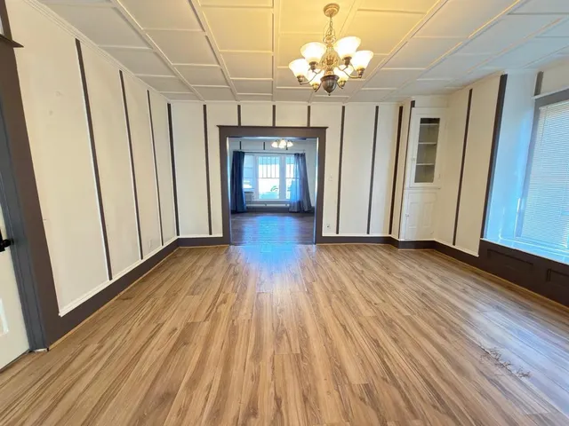 a view of a room with wooden floors and chandelier
