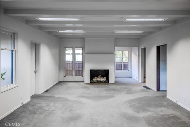 a view of an empty room with a fireplace and a window