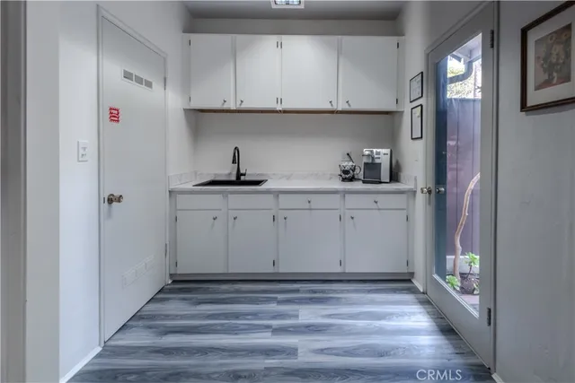 a view of cabinets a sink and wooden floor
