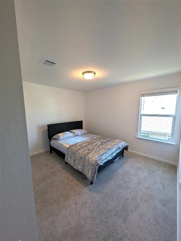 a bedroom with a bed and window