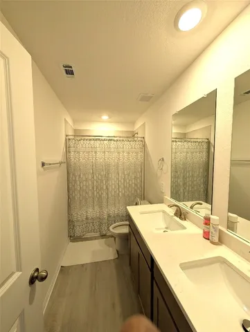 a bathroom with a tub sink shower and a mirror