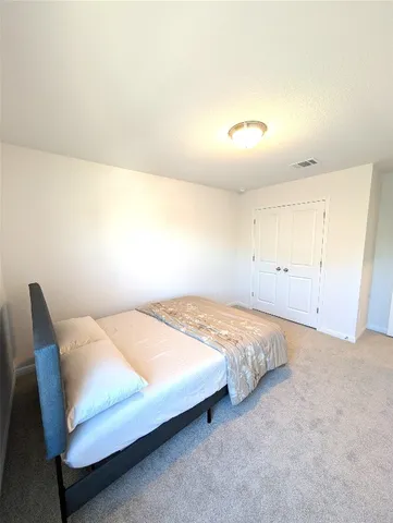 a bedroom with a bed and chair