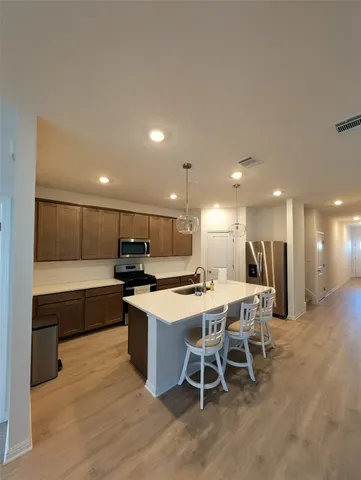 a kitchen with a dining table chairs sink and cabinets