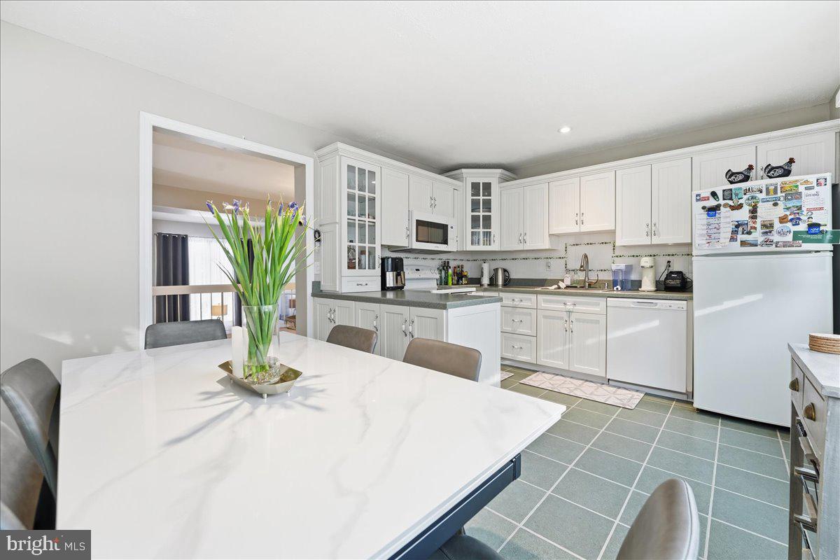 159 Henderson Place Hightstown, NJ 08520 - Photo 12 of 32 a kitchen with a white table and chairs