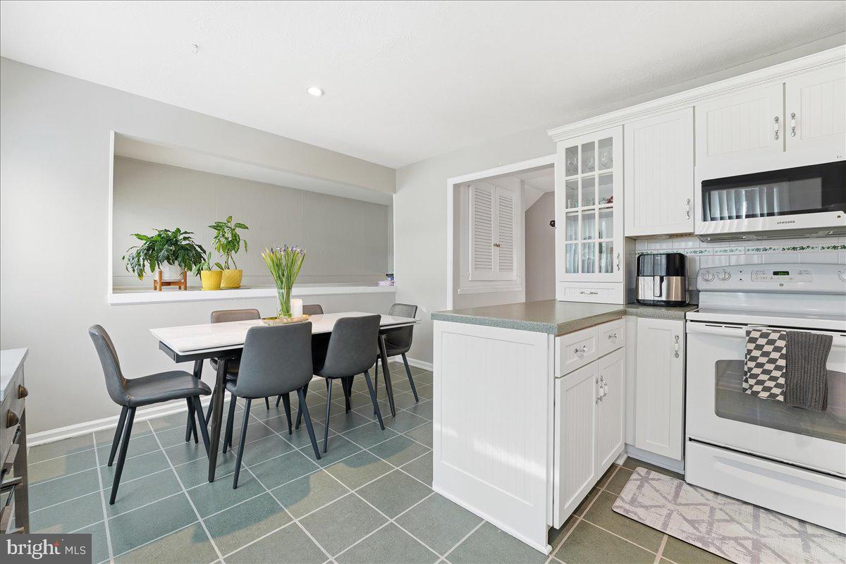 159 Henderson Place Hightstown, NJ 08520 - Photo 10 of 32 a kitchen with stainless steel appliances granite countertop a table and chairs