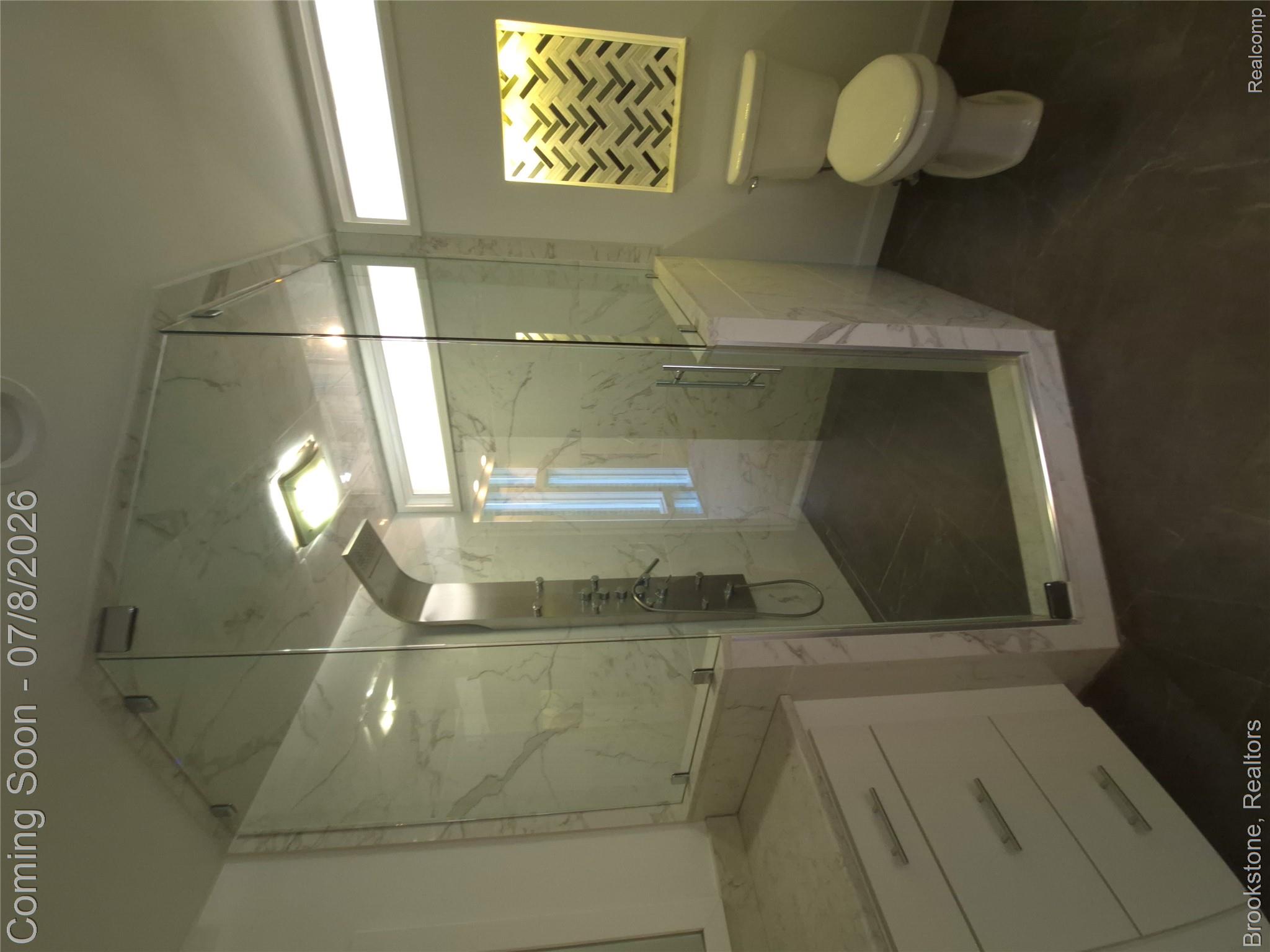 4140 South Henderson Road Davison, MI 48423 - Photo 50 of 98 Glass-enclosed shower with a rainfall showerhead, marble-patterned tile surround, and dark-toned floor tiles