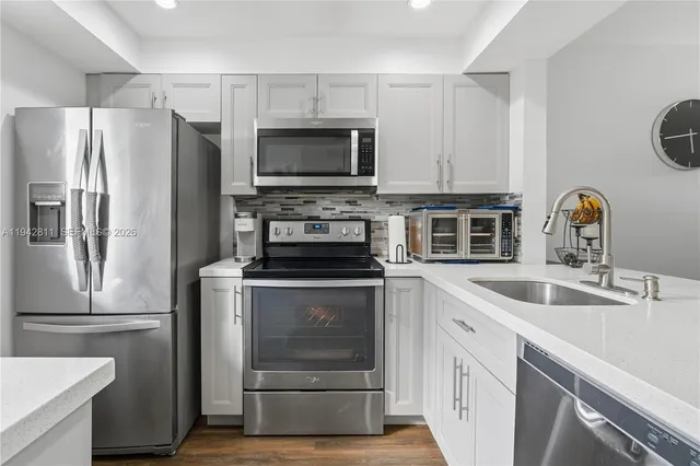 a kitchen with white cabinets and stainless steel appliances