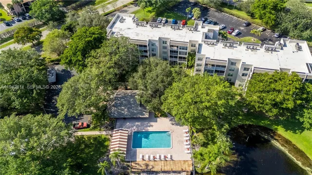 an aerial view of residential house with outdoor space and trees all around