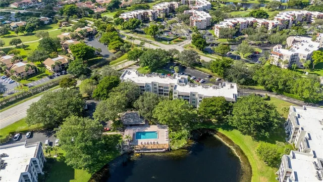 an aerial view of lake and residential houses with outdoor space and swimming pool