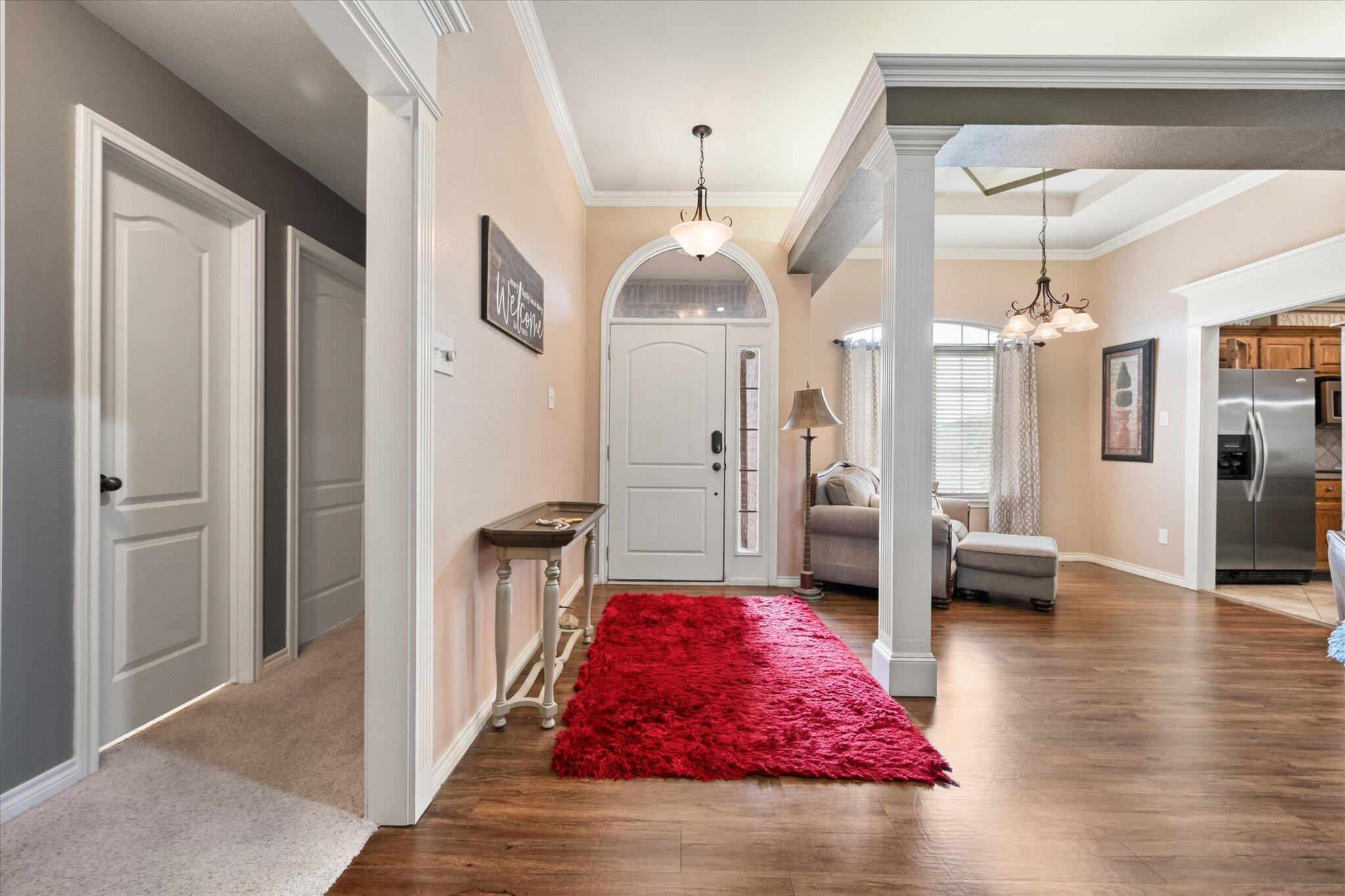 5838 101st Street Lubbock, TX 79424 - Photo 11 of 37 a hall way with furniture a rug and a chandelier
