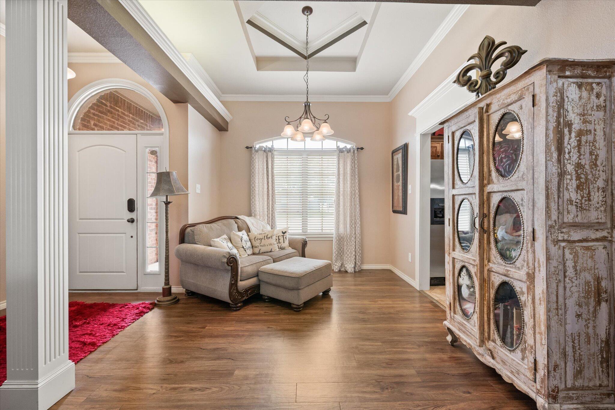 5838 101st Street Lubbock, TX 79424 - Photo 13 of 37 a living room with furniture a fireplace and a chandelier