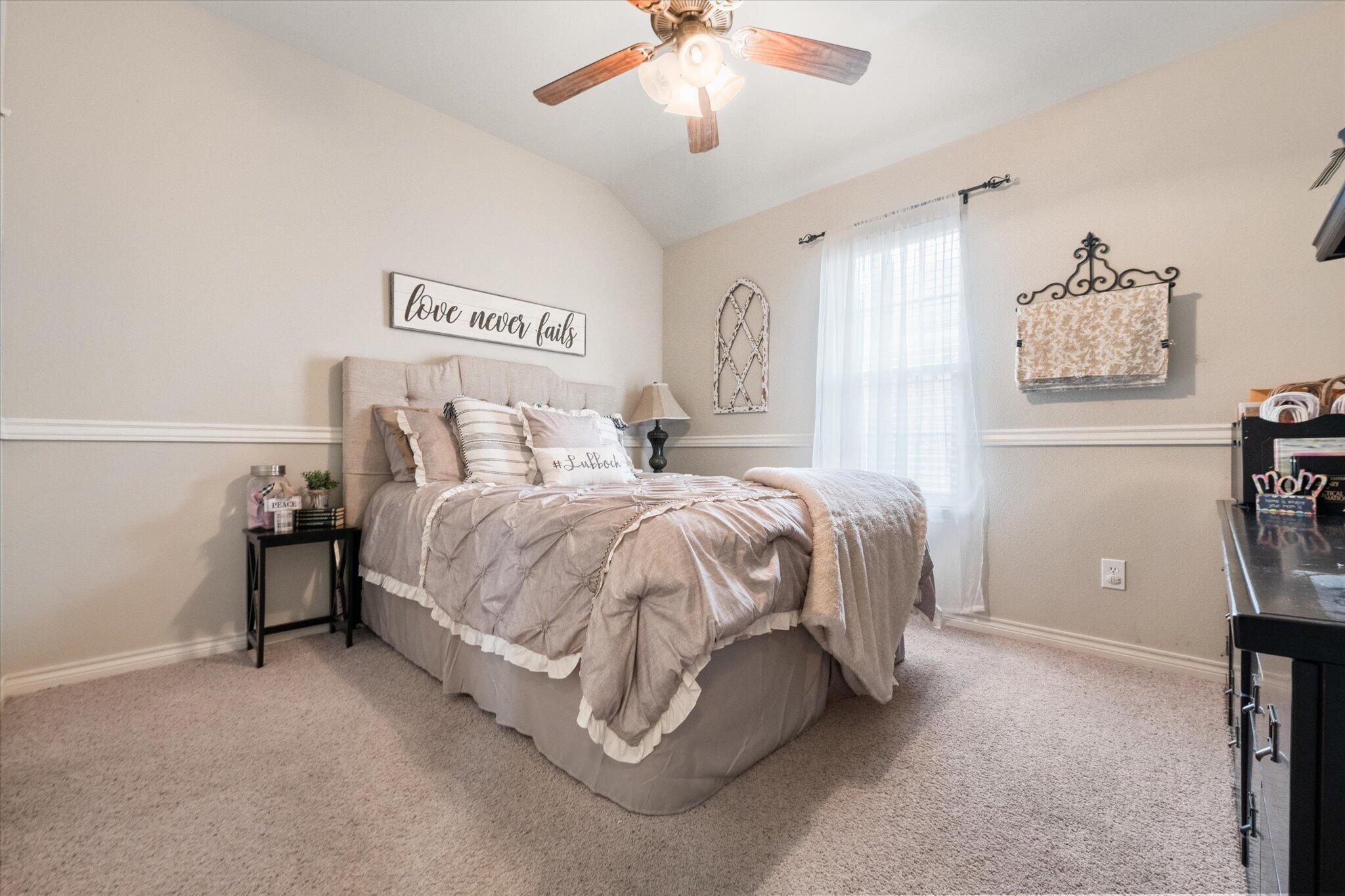5838 101st Street Lubbock, TX 79424 - Photo 29 of 37 a spacious bedroom with a bed and a chandelier