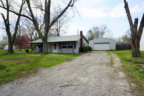 a front view of a house with a yard and trees