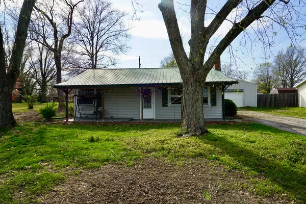 a view of a house with backyard and a tree
