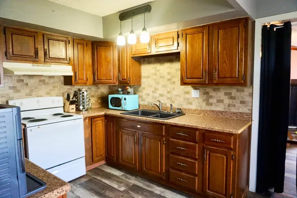 a kitchen with stainless steel appliances granite countertop wooden cabinets a sink and dishwasher