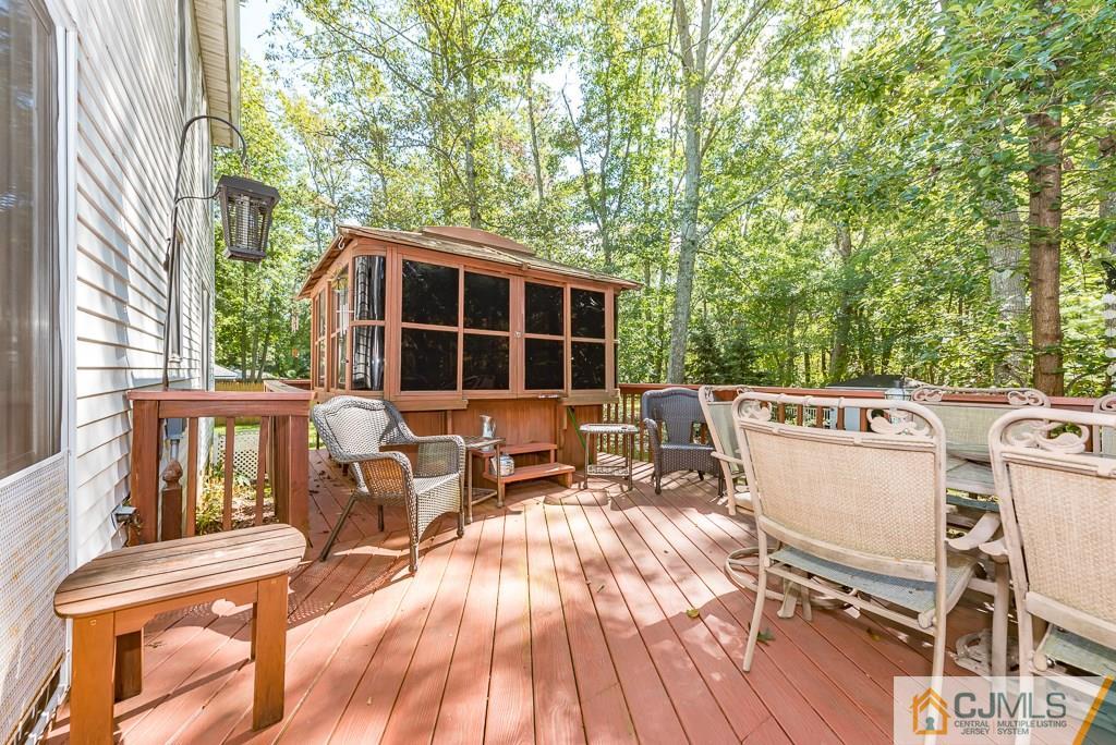 14 Crest Road Jackson, NJ 08527 - Photo 22 of 24 a view of a patio with table and chairs with wooden floor and fence