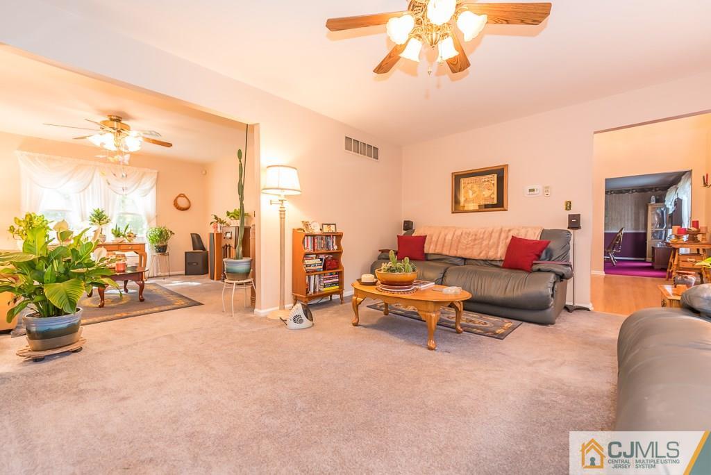 14 Crest Road Jackson, NJ 08527 - Photo 5 of 24 a living room with furniture a chandelier and a dining table