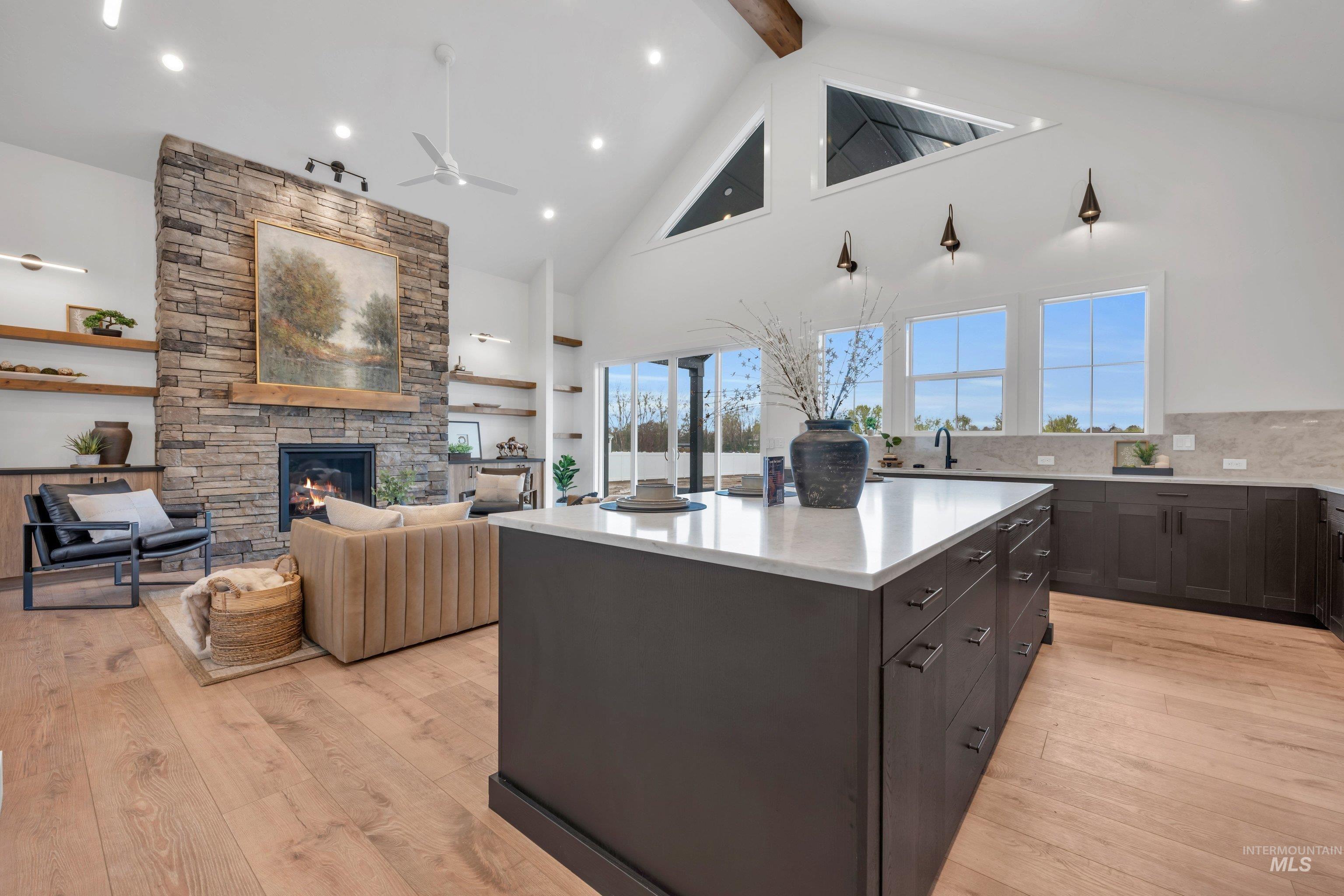 24871 Ardmore Court Caldwell, ID 83607 - Photo 44 of 44 Kitchen with a kitchen island, a fireplace, open floor plan, dark wood finish cabinetry, and light wood-style flooring