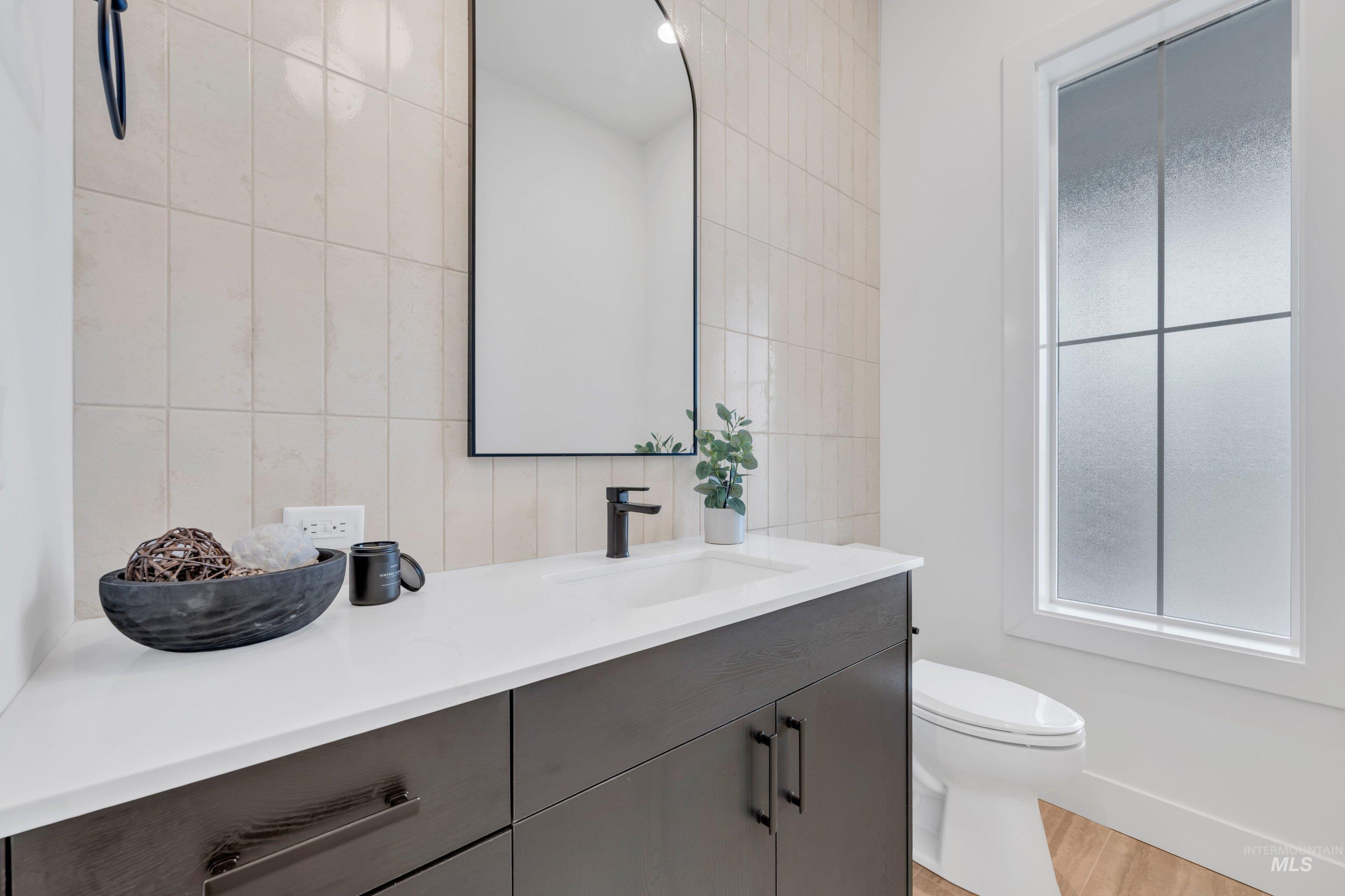 24871 Ardmore Court Caldwell, ID 83607 - Photo 20 of 44 Bathroom featuring vanity, tile walls, and light wood finished floors