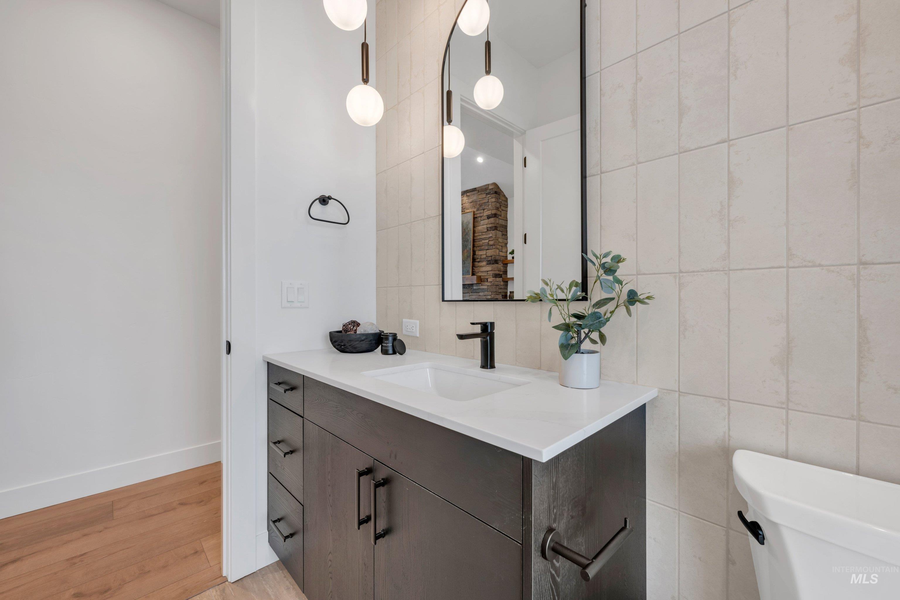 24871 Ardmore Court Caldwell, ID 83607 - Photo 21 of 44 Bathroom featuring tile walls, vanity, and light wood-style flooring