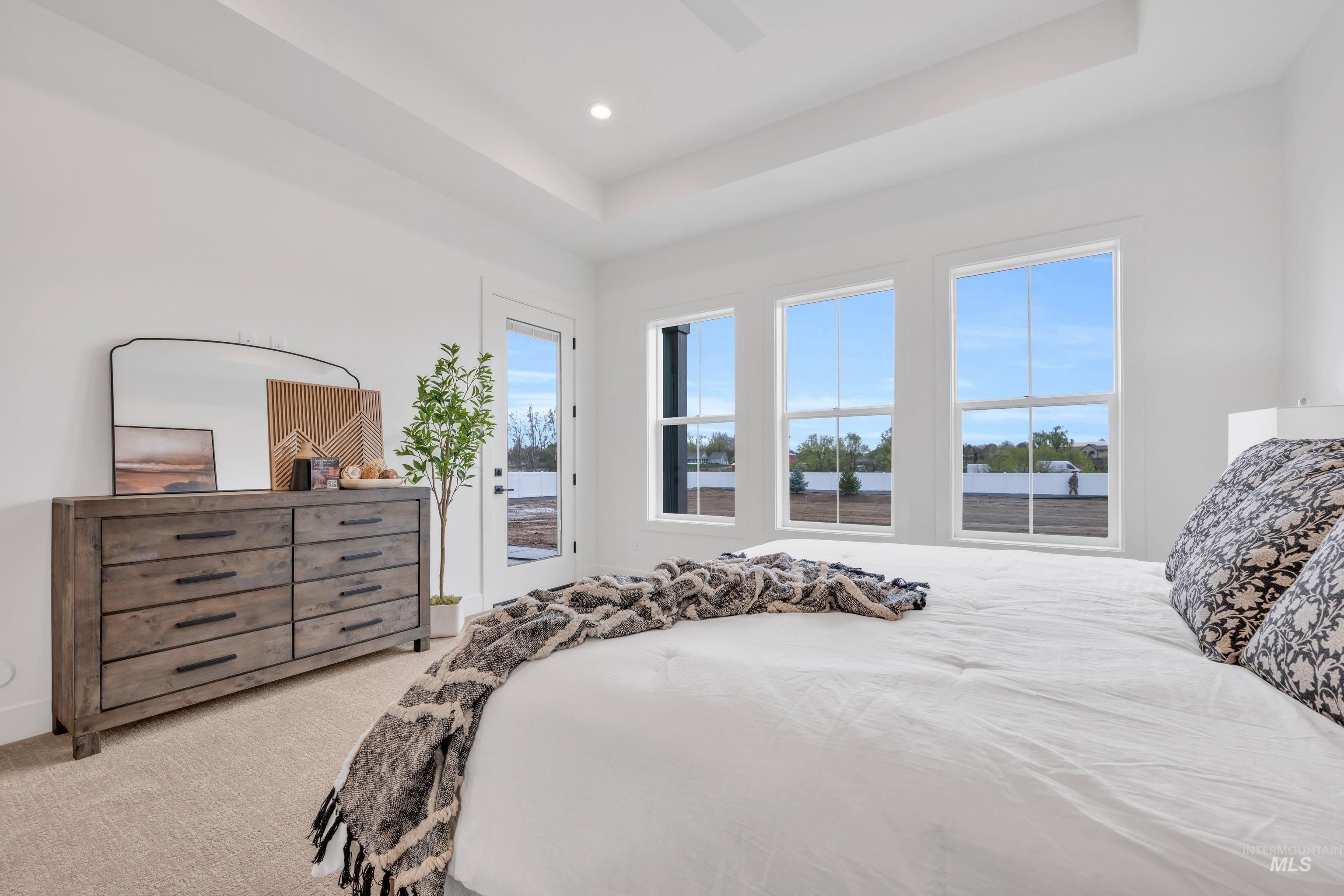 24871 Ardmore Court Caldwell, ID 83607 - Photo 27 of 44 Bedroom with light colored carpet, a ceiling fan, access to exterior, a raised ceiling, and recessed lighting