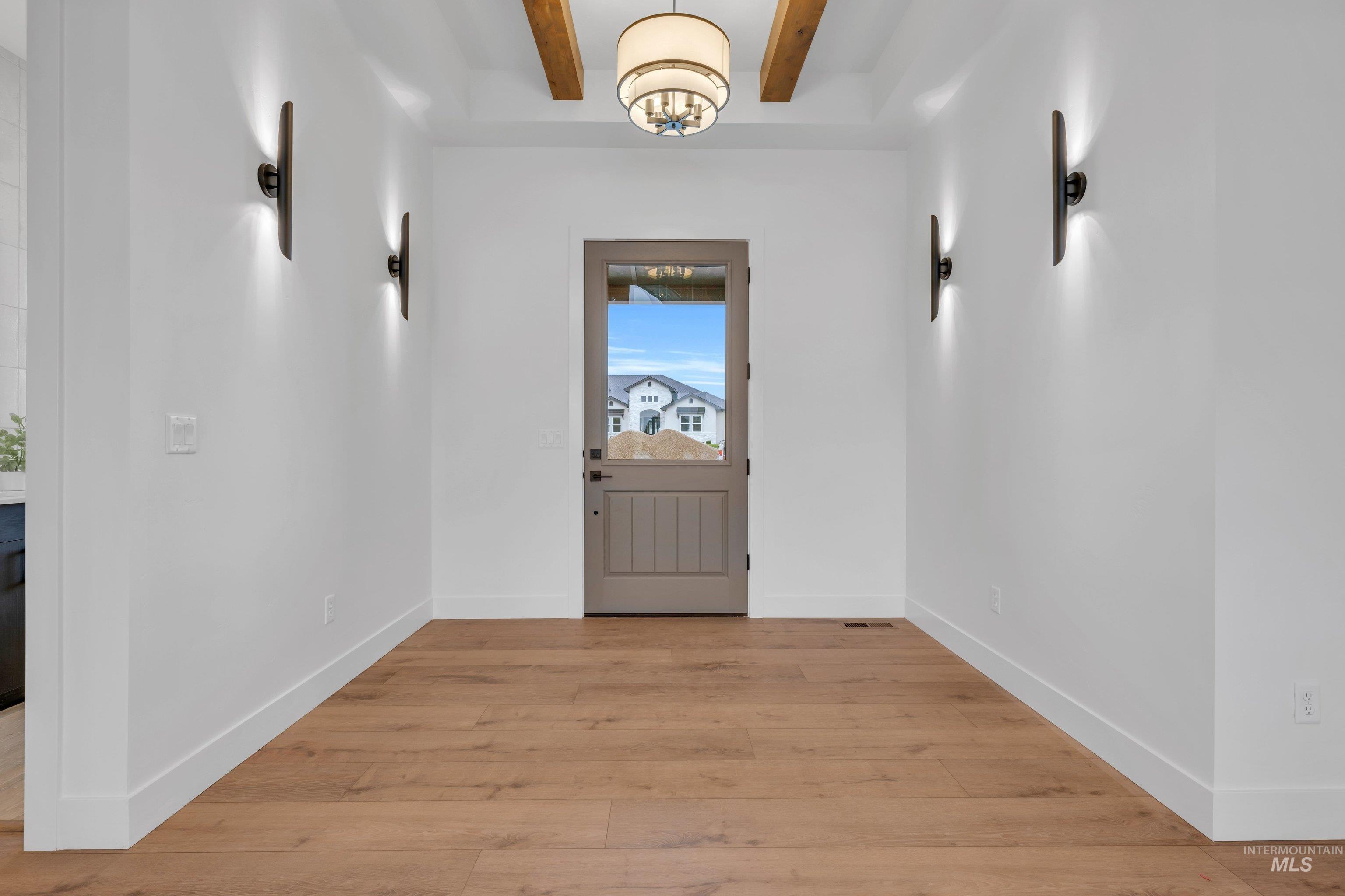 24871 Ardmore Court Caldwell, ID 83607 - Photo 3 of 44 Doorway to outside with beam ceiling and wood-type flooring